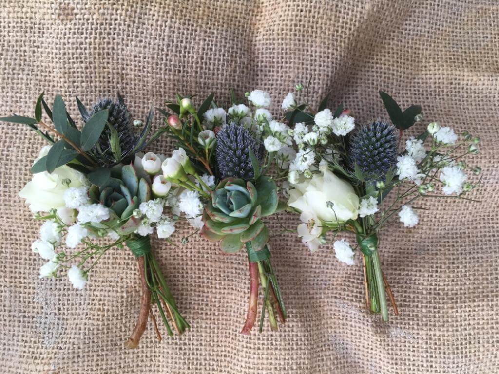 Buttonholes with spray roses, gypsophila, thistles and succulents